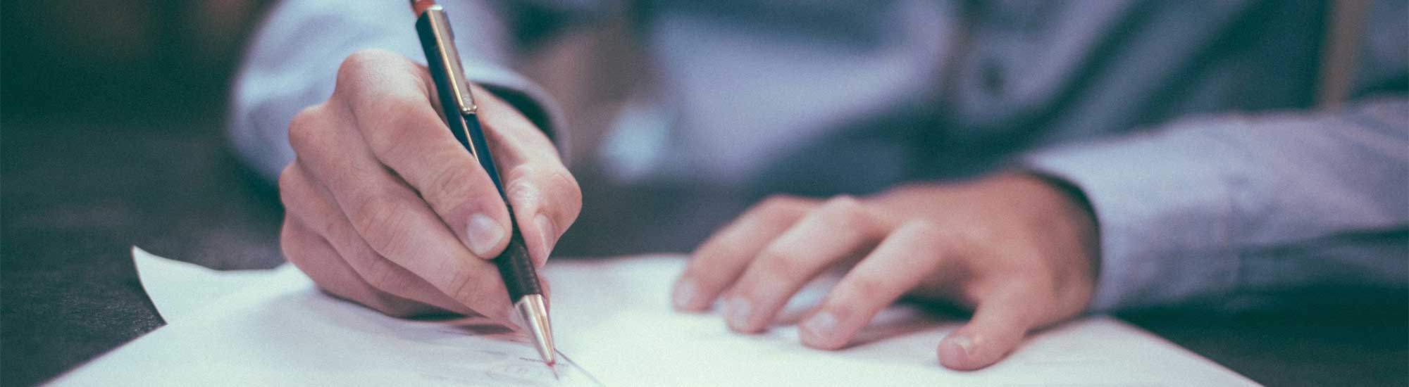 Person writing with pen and paper